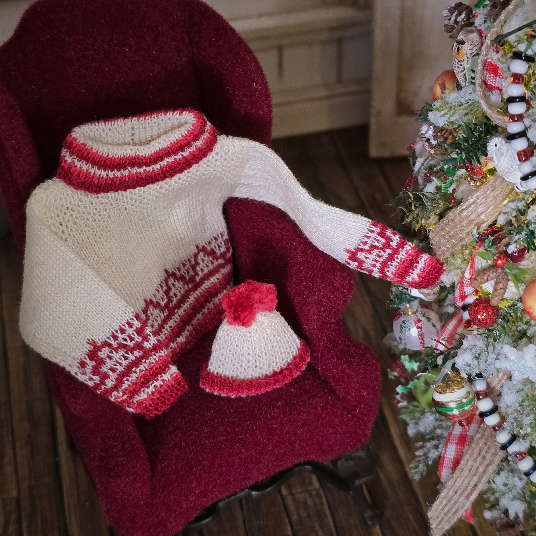Knitted sweater and hat set with Christmas tree in the background