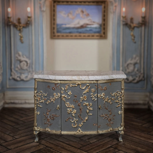 Decorative miniature sideboard cabinet with gold embellishments in a classical room setting. Cristina Noriega Moran