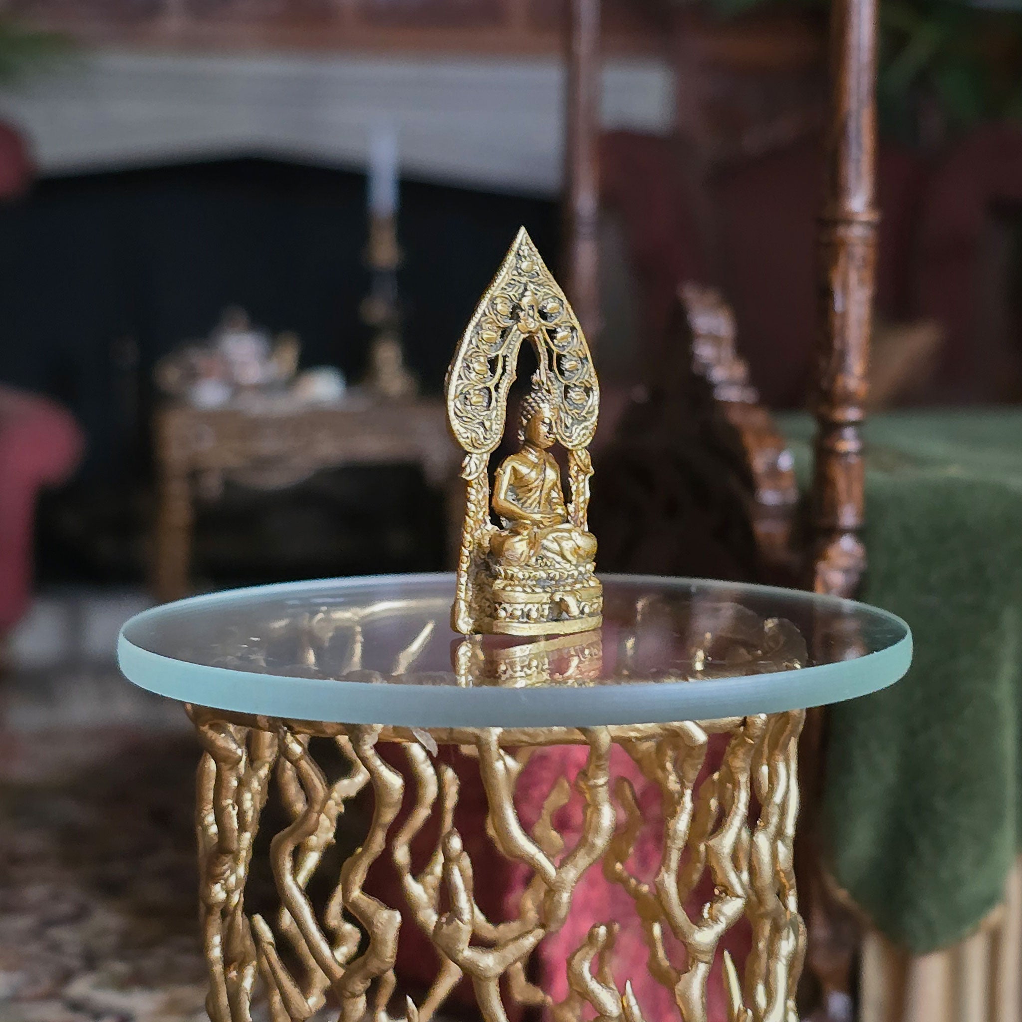 Gold Buddha statue on a decorative table with a blurred indoor background