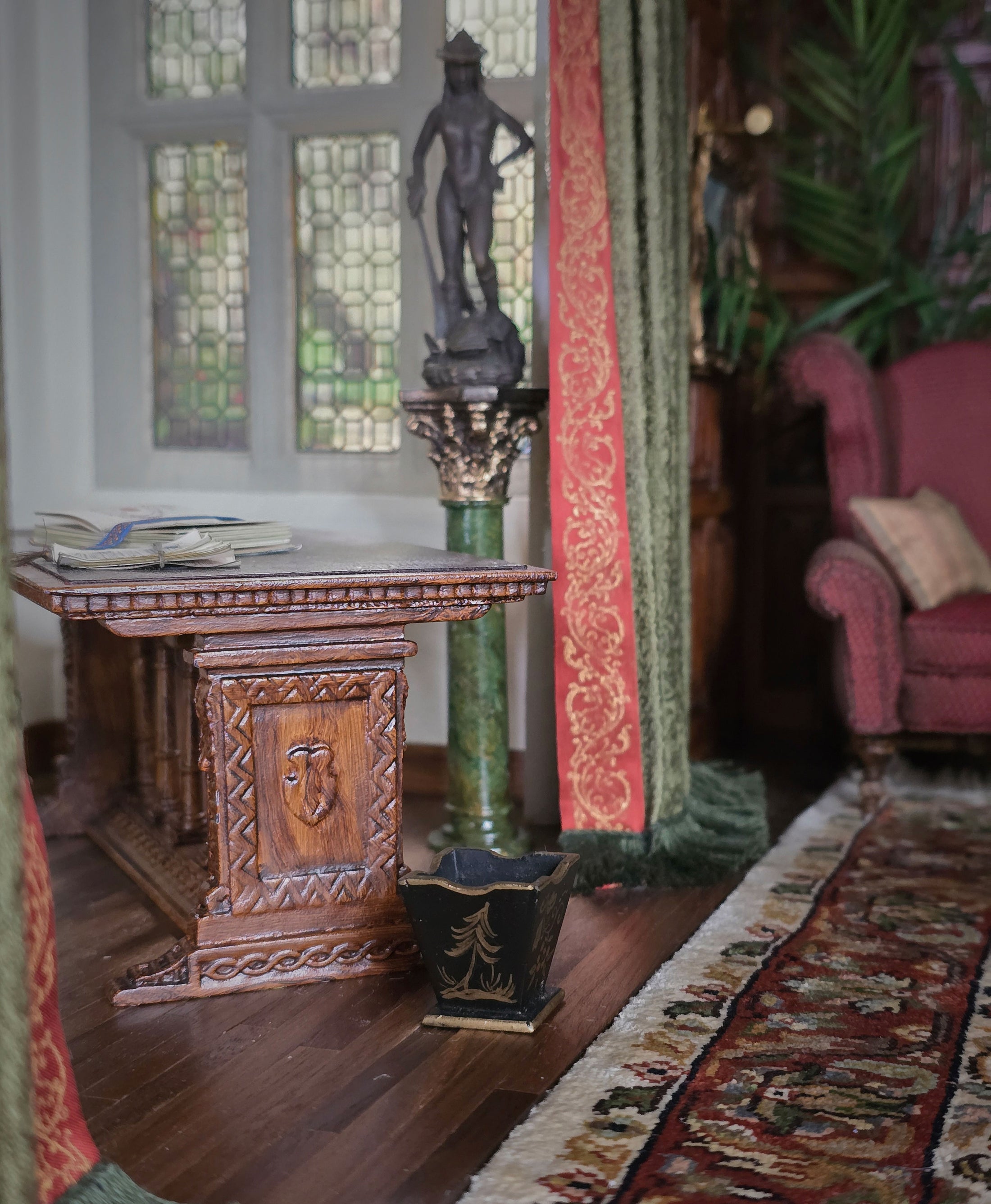Decorative interior with a wooden table, statue, and armchair.