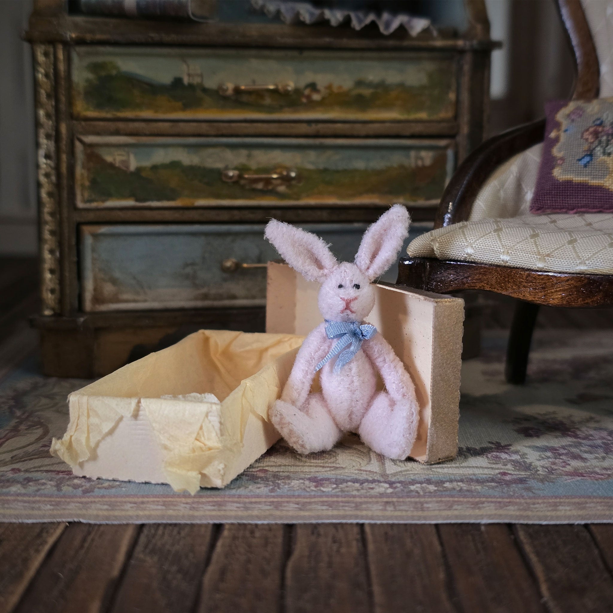 Pink stuffed bunny with a blue bow tie sitting in a vintage room.