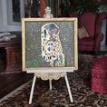 Load image into Gallery viewer, Decorative painting of 'The Kiss' by Gustav Klimt on an easel in a room setting, by Sam Kelm in miniature
