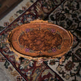 Load image into Gallery viewer, Decorative wooden tabletop with intricate carvings on a patterned rug
