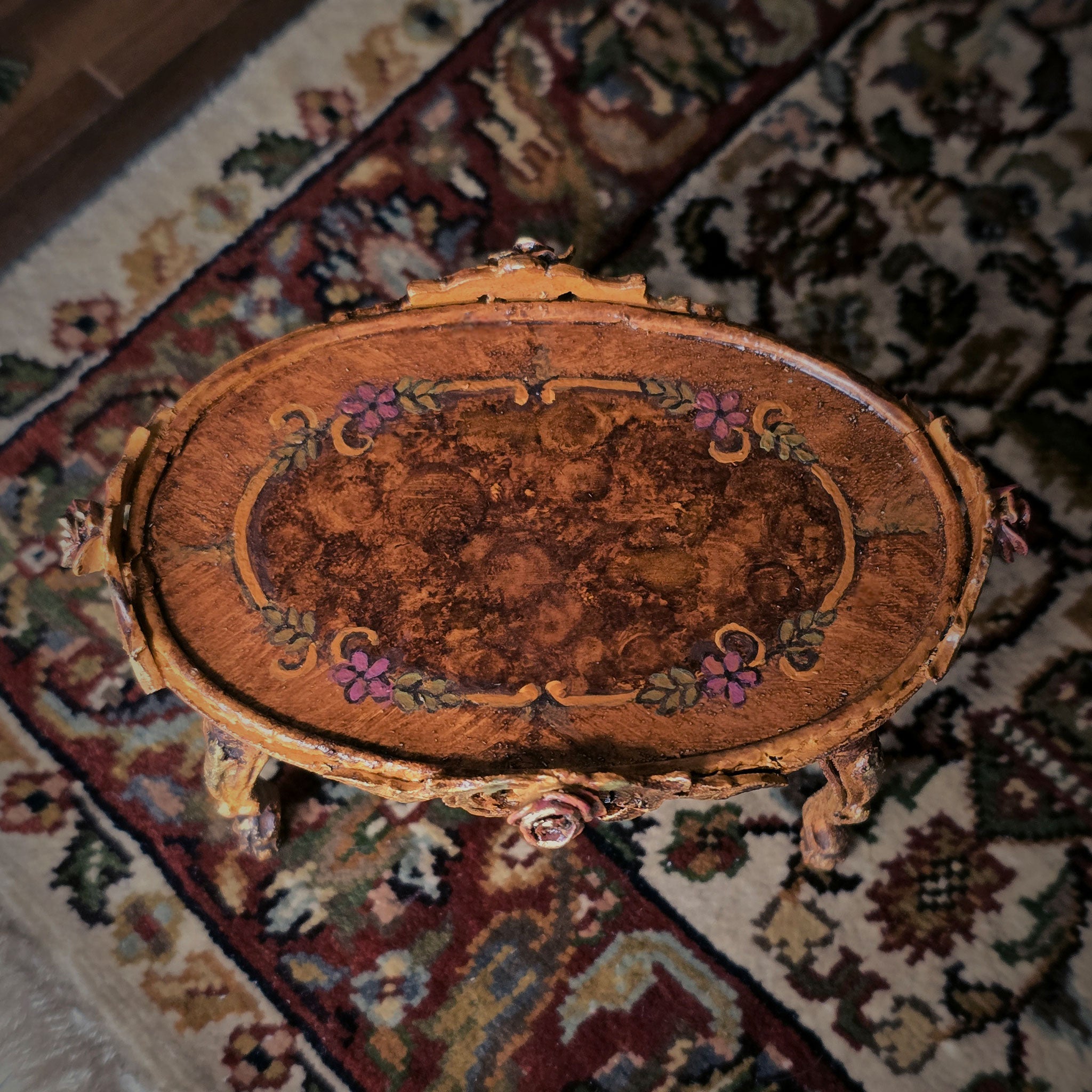 Decorative wooden tabletop with intricate carvings on a patterned rug