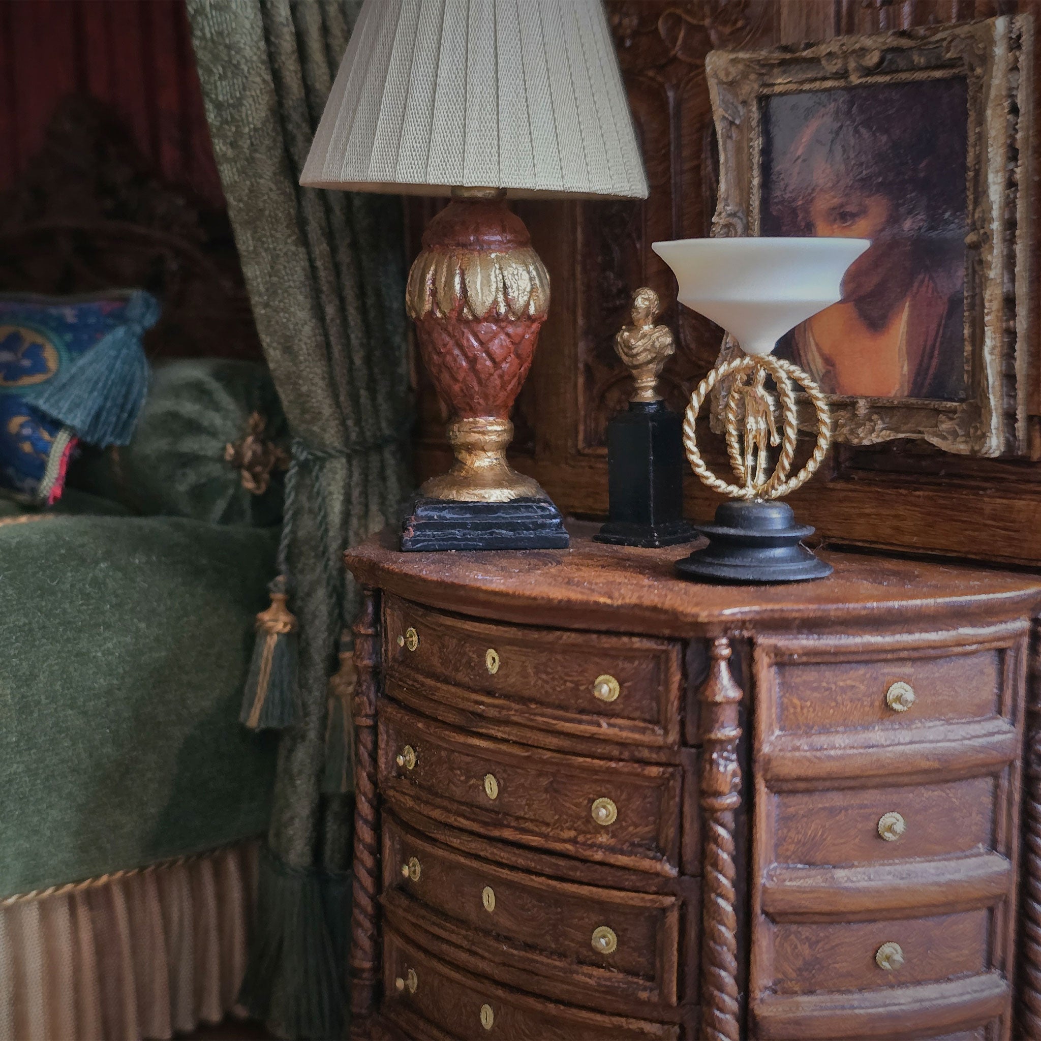Decorative sculpture with a metal male figure on a black base in a warm, indoor miniature setting.