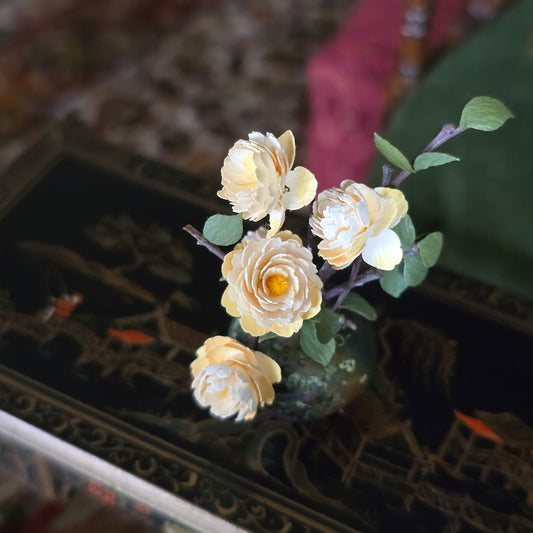 Decorative yellow flowers on a reflective surface with a blurred background