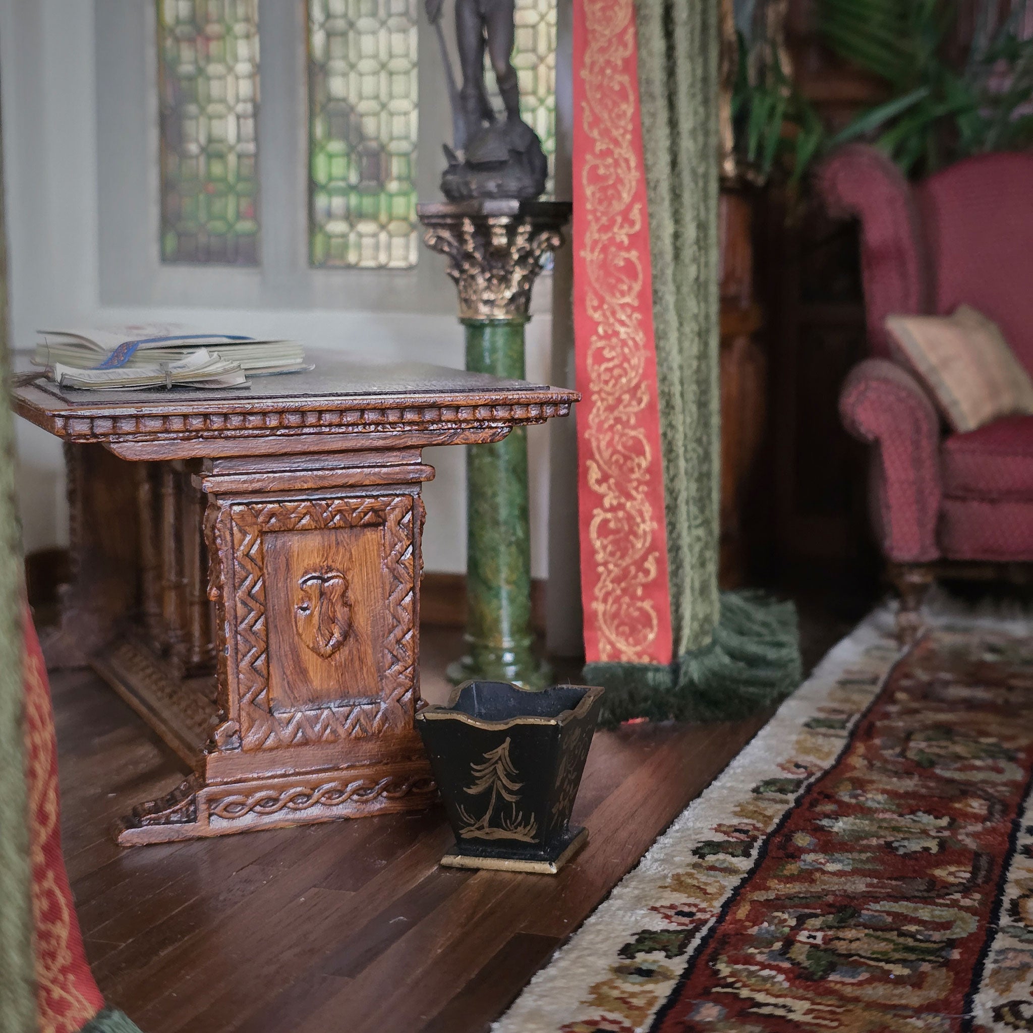 Decorative interior setting with a wooden table, green column, and pink chair.