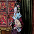 Load image into Gallery viewer, Traditional doll in a decorative setting with a red lacquer background
