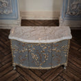 Load image into Gallery viewer, Decorative sideboard cabinet in miniature with marble top and gold leaf detailing on a wooden floor.
