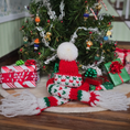 Load image into Gallery viewer, Dollhouse miniature Knitted hat and scarf with a Christmas tree and presents in the background
