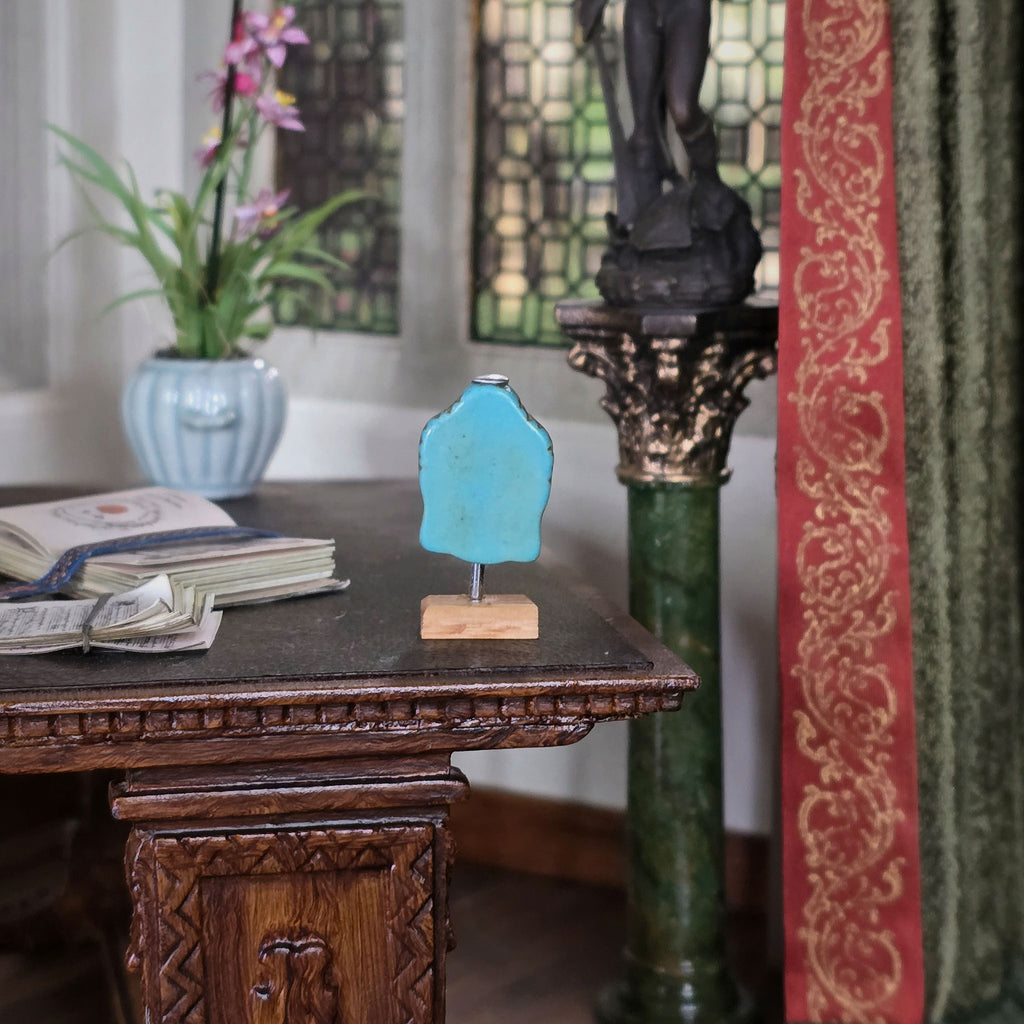 Back of sculpture on a wooden stand with a decorative background