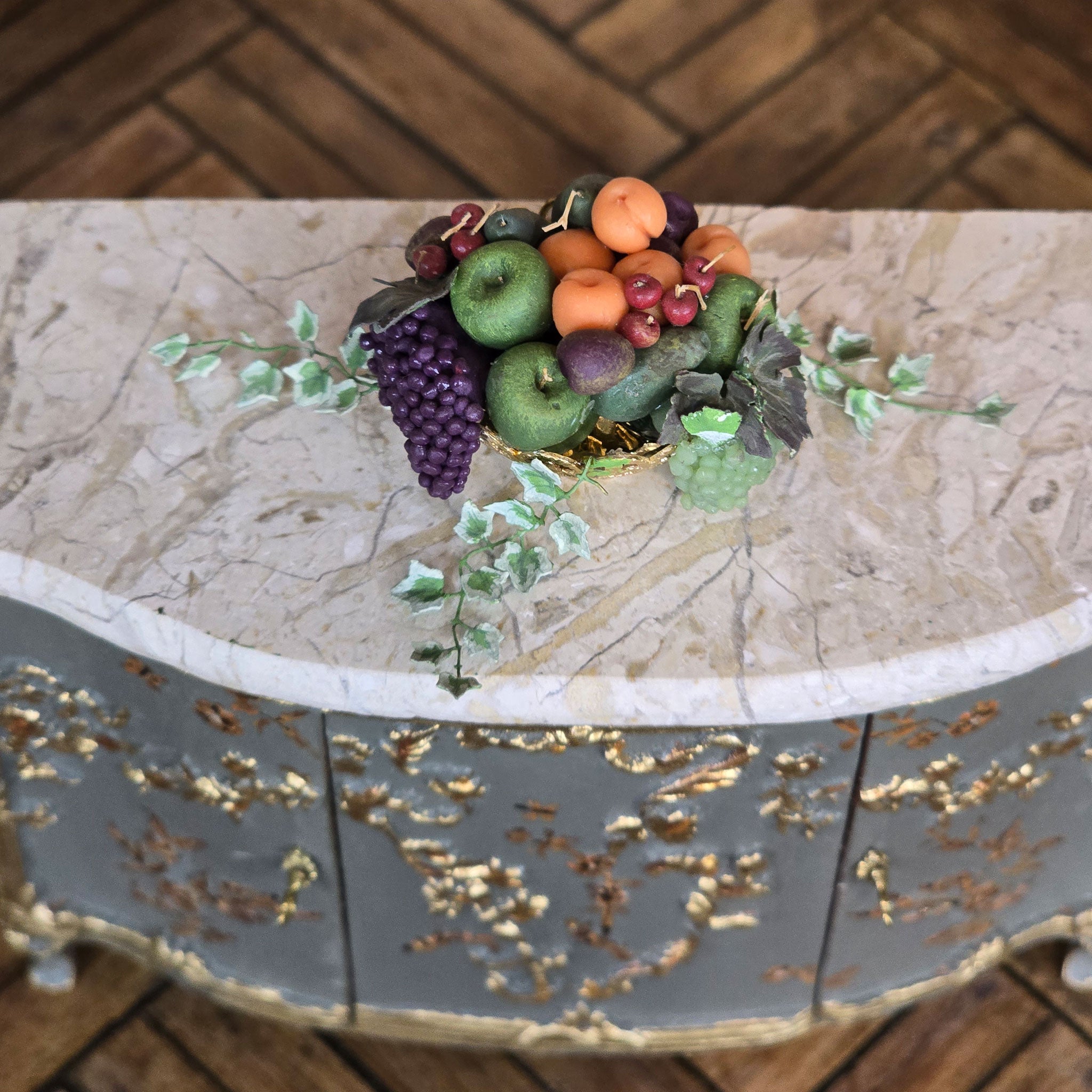 Decorative miniature dollhouse fruit arrangement on a marble surface