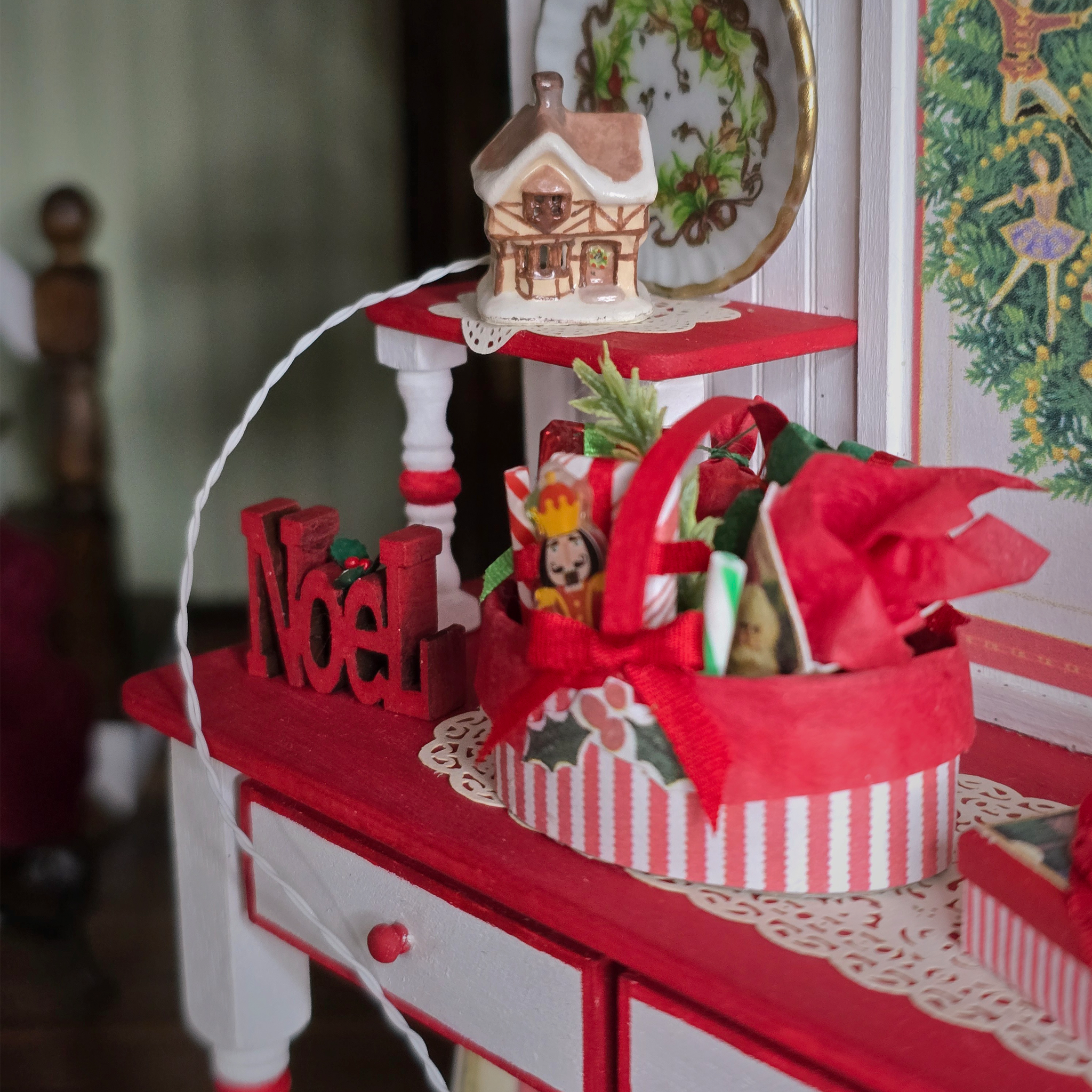 Dollhouse Miniature Light-Up English Cottage, on a decorated holiday shelf