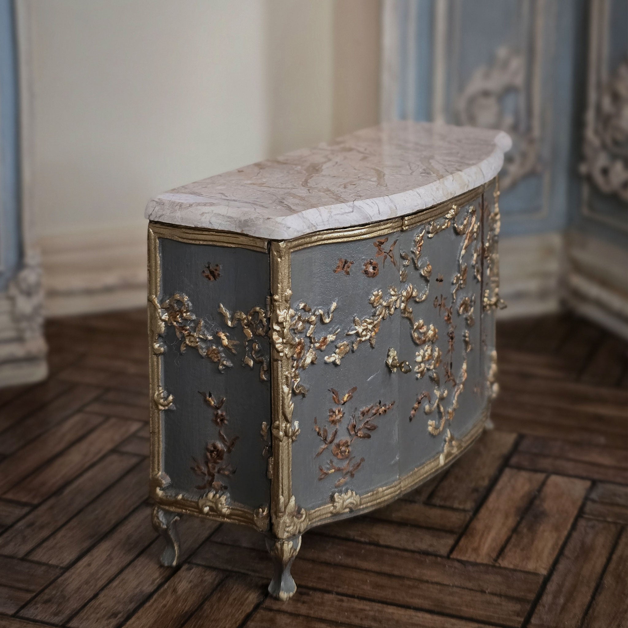 Decorative sideboard with marble top and gold floral embellishments in a room setting by Cristina Noriega Moran