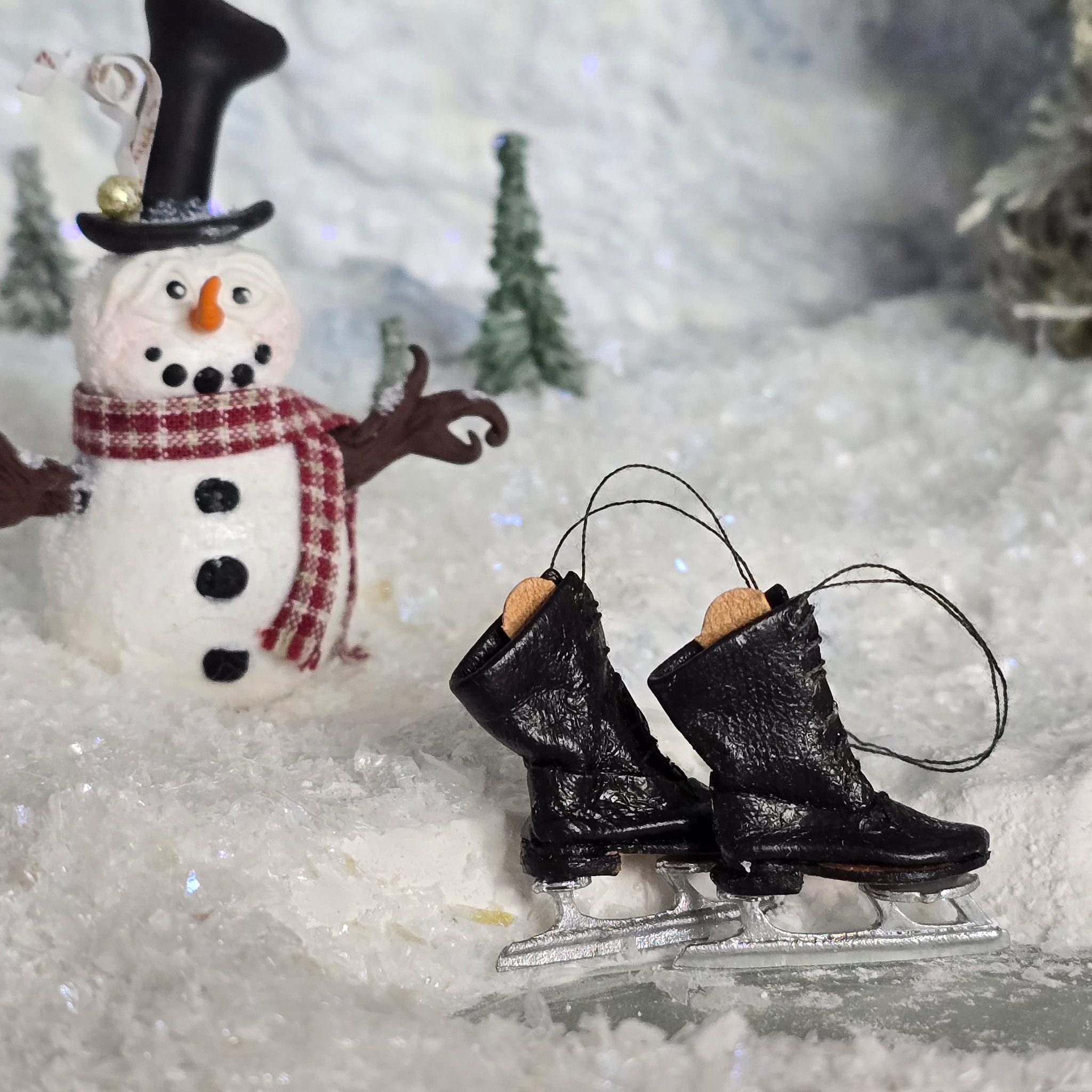 Dollhouse miniature  ice skates with a snowman and snowy background