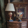 Load image into Gallery viewer, Decorative lamp and framed picture with a decorative sculpture with a metal male figure on a black base.
