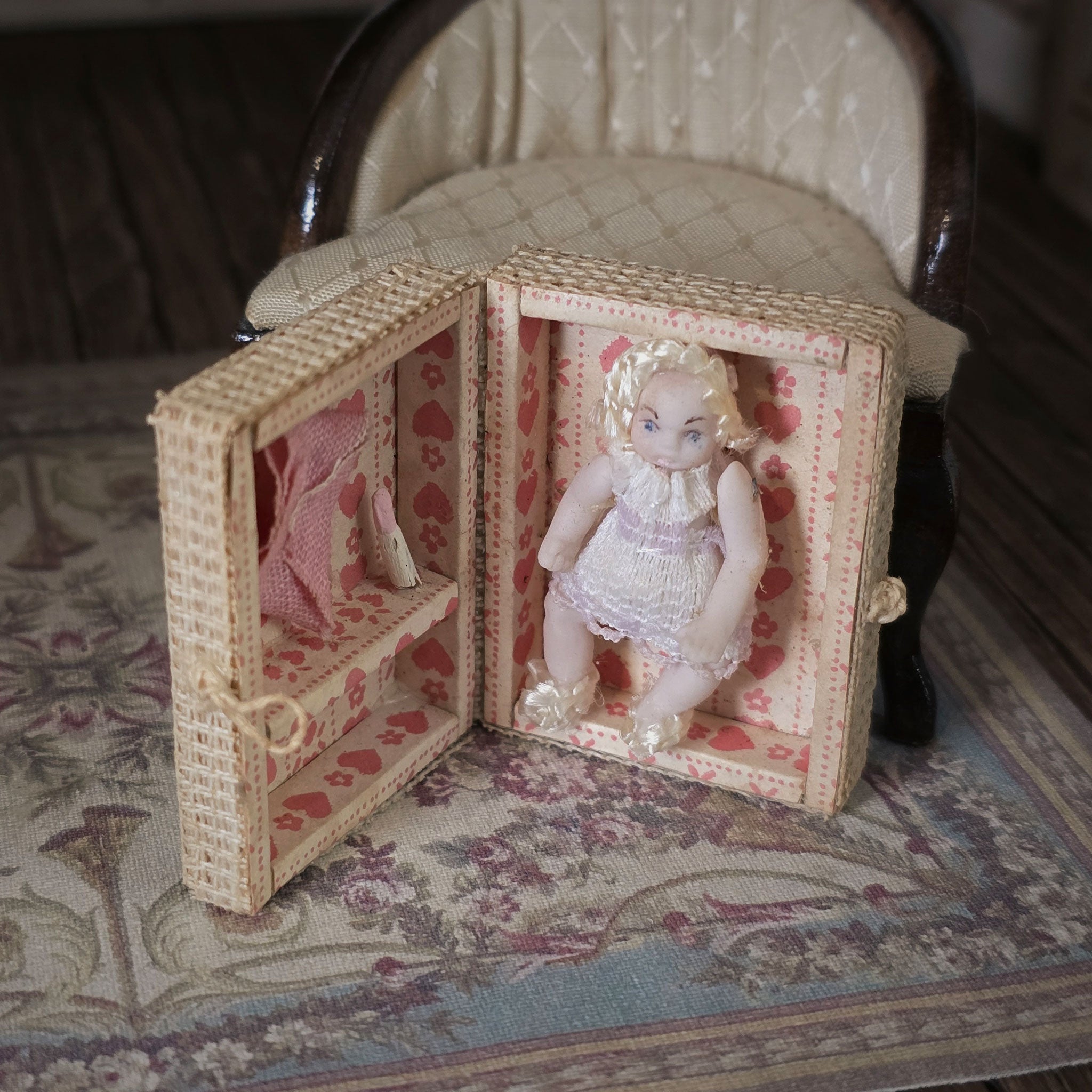 Small doll in a decorative box on a patterned surface