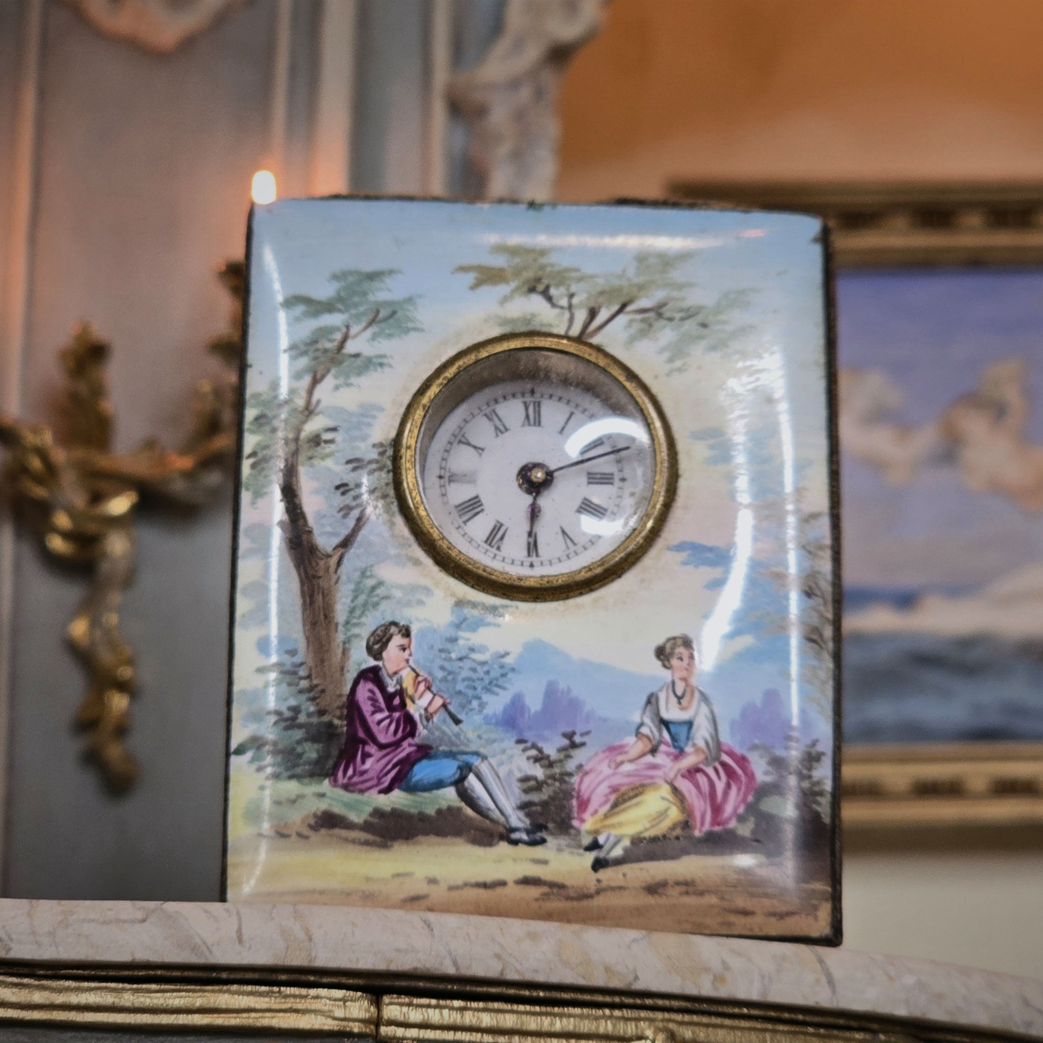 Decorative clock and scenic illustration of two people in a garden.
