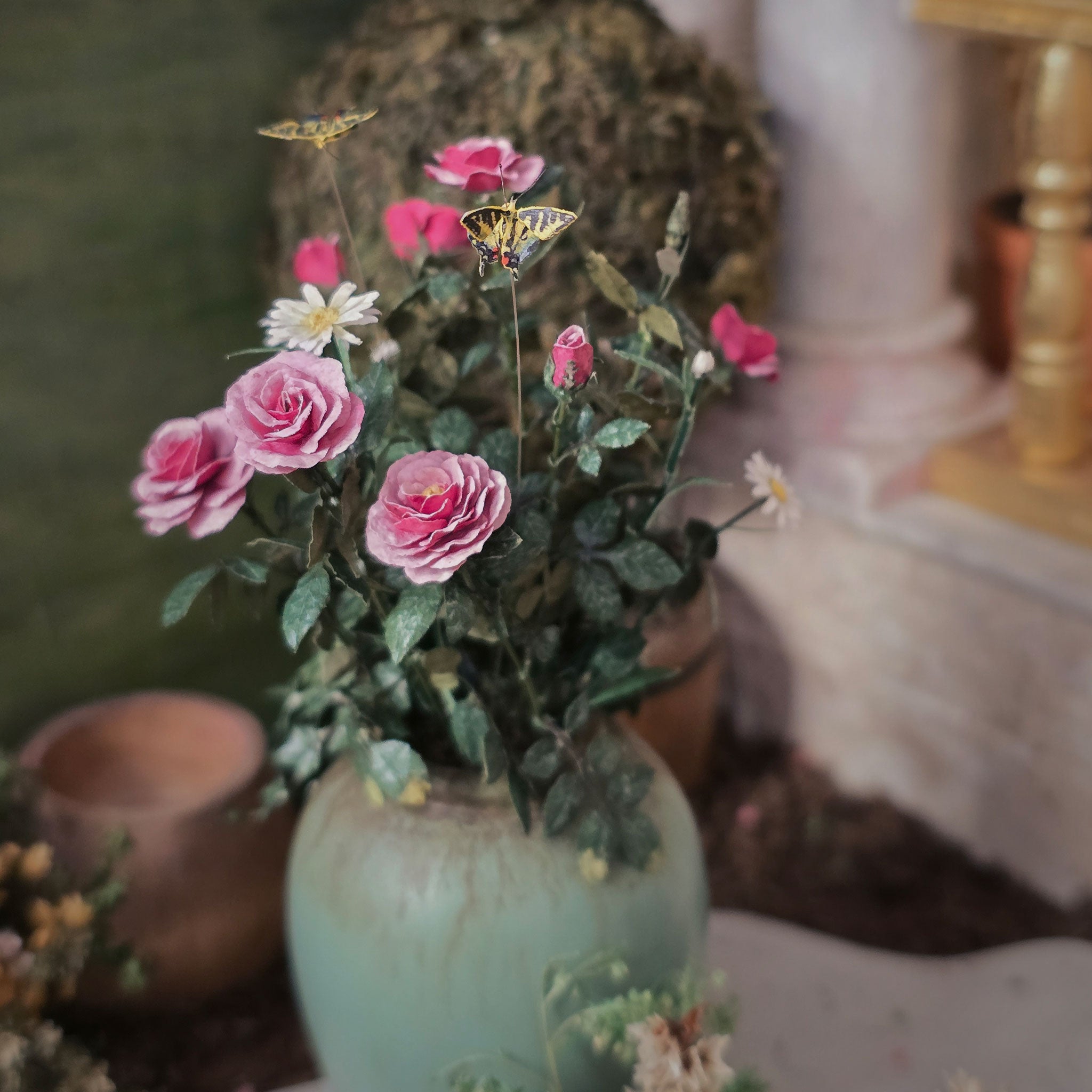 Planter with pink flowers and butterflies on a blurred background