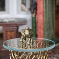 Load image into Gallery viewer, Gold elephant figurine on a glass table with a blurred indoor background

