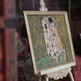 Load image into Gallery viewer, Artistic depiction of 'The Kiss' by Gustav Klimt on a decorative stand.
