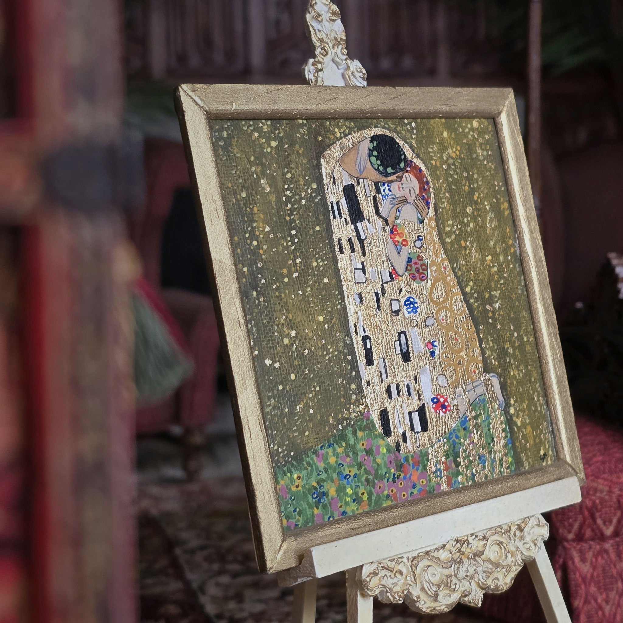 Artistic depiction of 'The Kiss' by Gustav Klimt on a decorative stand.