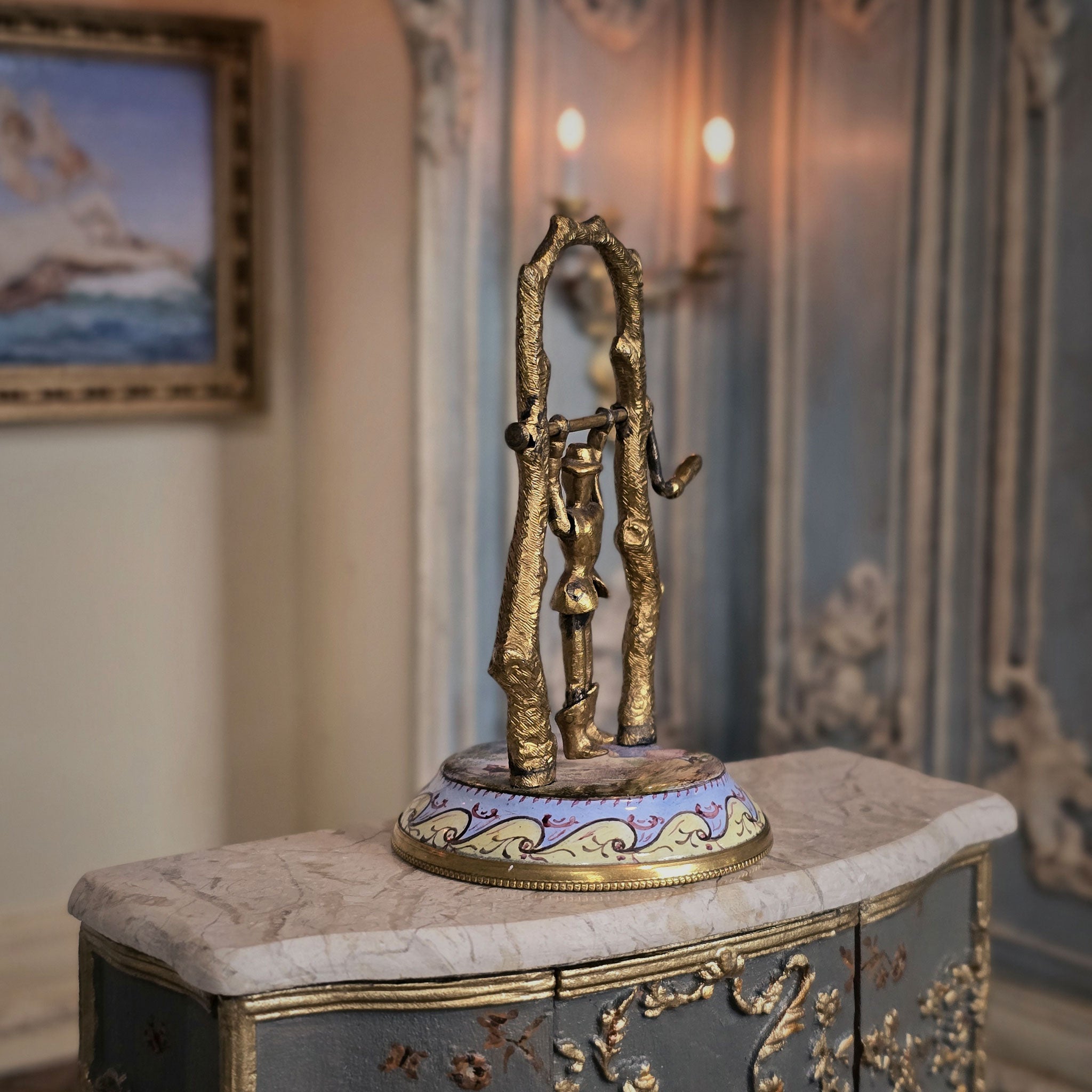 Side view of automata toy sculpture on a marble surface with a blurred background