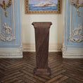Load image into Gallery viewer, Backside of wooden pedestal in a room with decorative furniture and a painting on the wall.
