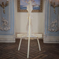 Load image into Gallery viewer, Back of wooden easel in an ornate room.
