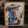 Load image into Gallery viewer, Artistic depiction of a woman holding a child with a wooden frame.
