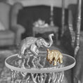 Load image into Gallery viewer, Two elephant figurines on a small round table with a blurred background
