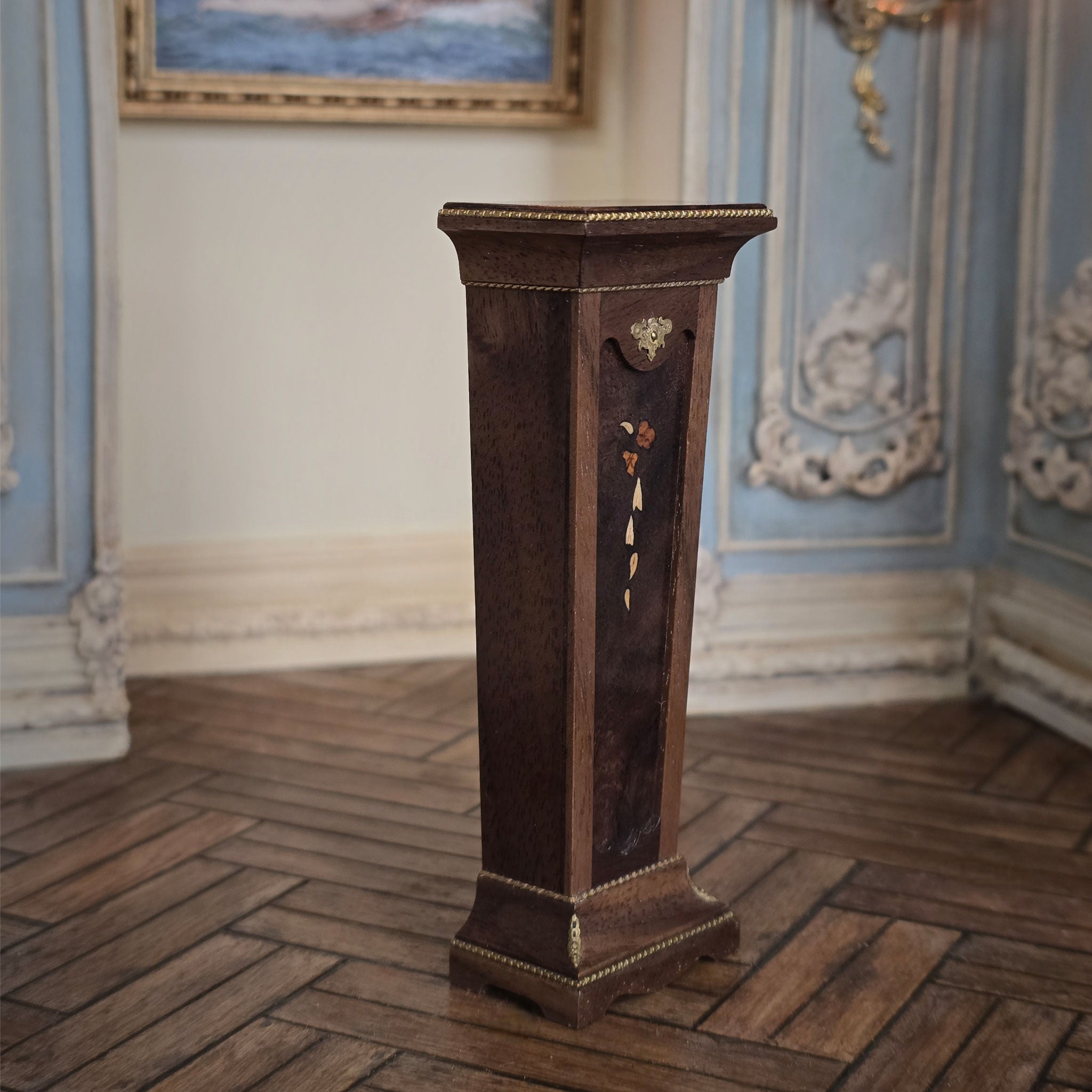 Wooden pedestal in a room with decorative walls and a painting, side view