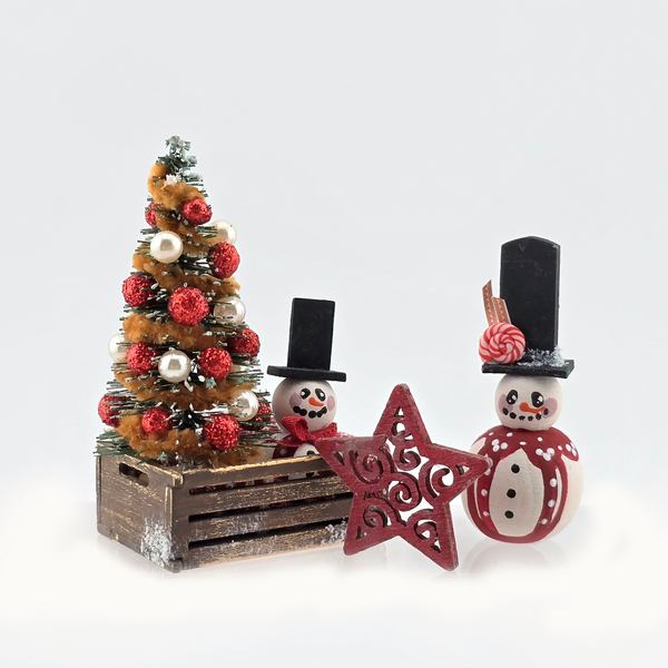 Decorative Christmas scene with a small tree, snowmen, and star on a white background