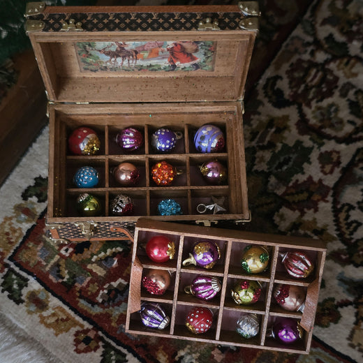 Wooden box with colorful glass ornaments on a patterned rug