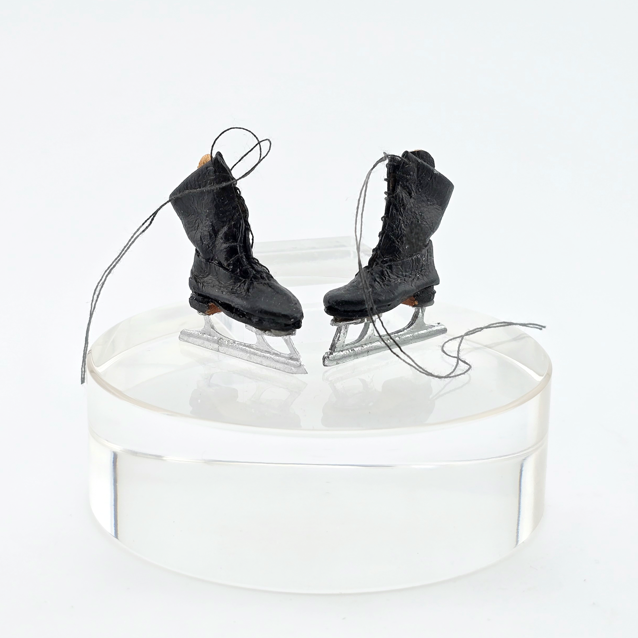 Dollhouse miniature Pair of black ice skates on a white background