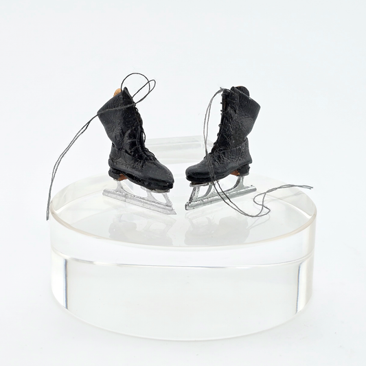 Dollhouse miniature Pair of black ice skates on a white background