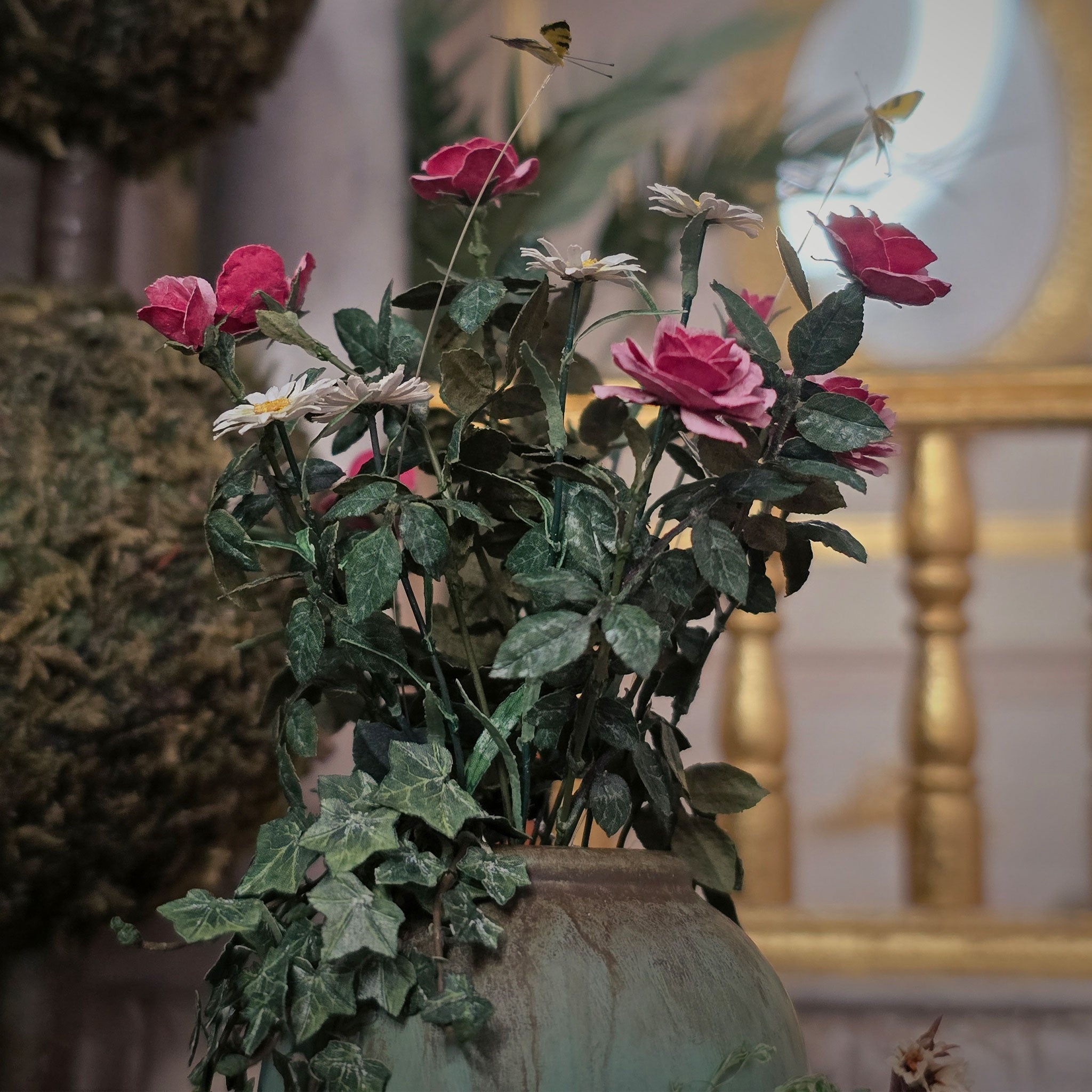 Decorative floral arrangement in a planter pot with a blurred indoor background