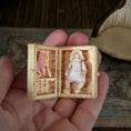 Load image into Gallery viewer, Miniature box with a porcelain baby doll and heart designs held in a hand.
