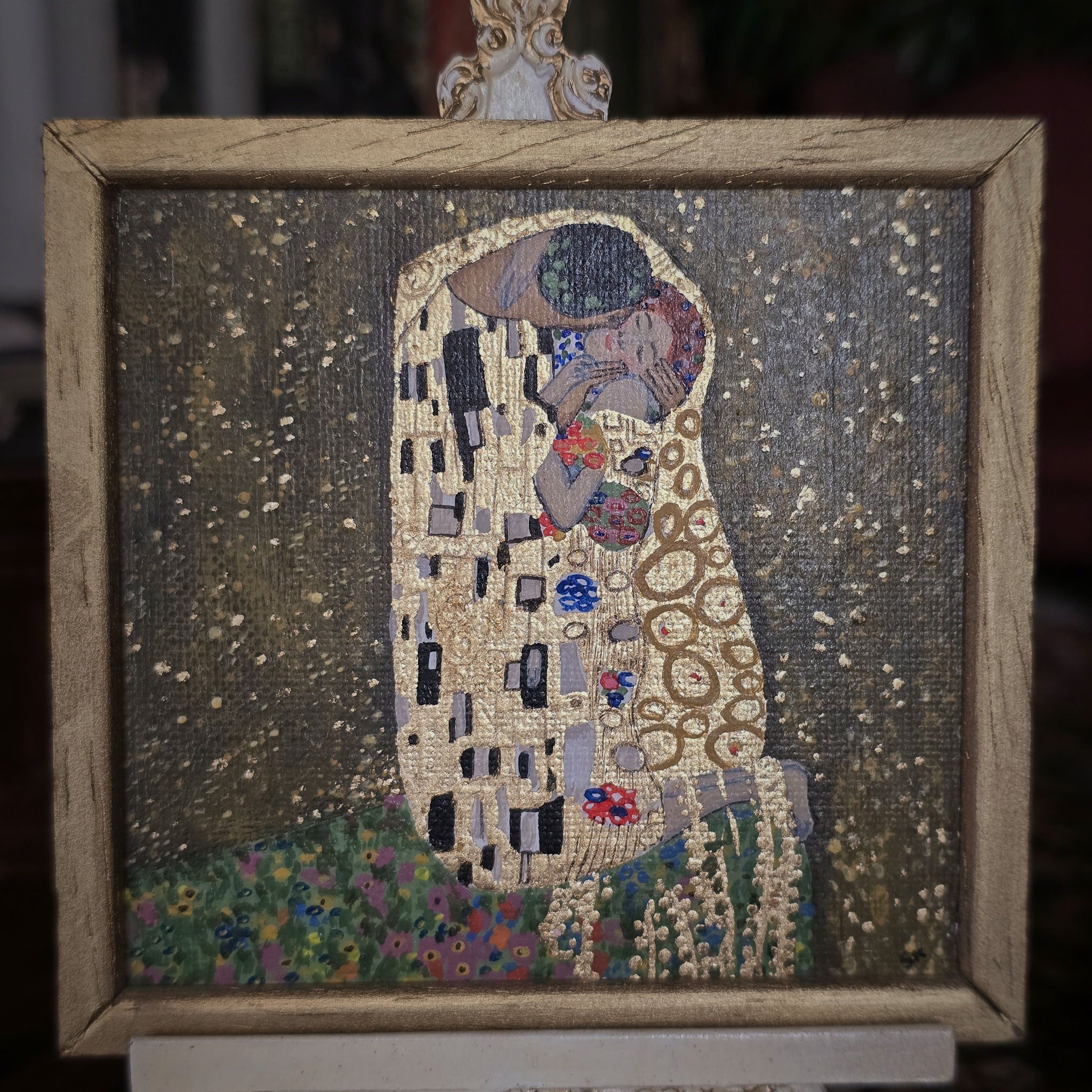Framed painting of a couple embracing, inspired by Gustav Klimt's style.