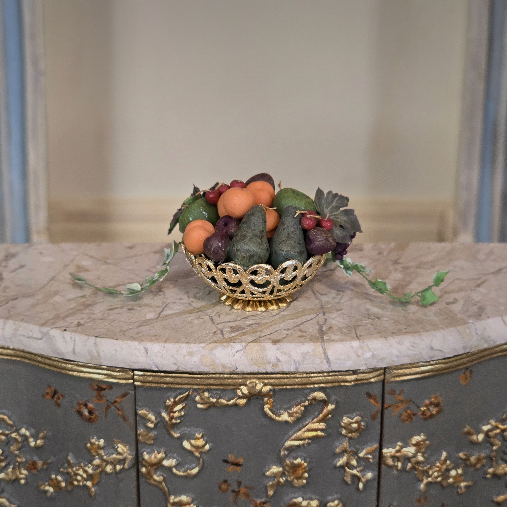 Decorative bowl with fruits on a marble surface with gold accents
