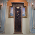 Load image into Gallery viewer, Wooden pedestal with decorative elements against a blurred decorative wall.
