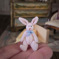 Load image into Gallery viewer, Small pink bunny toy held in a hand with a blurred background
