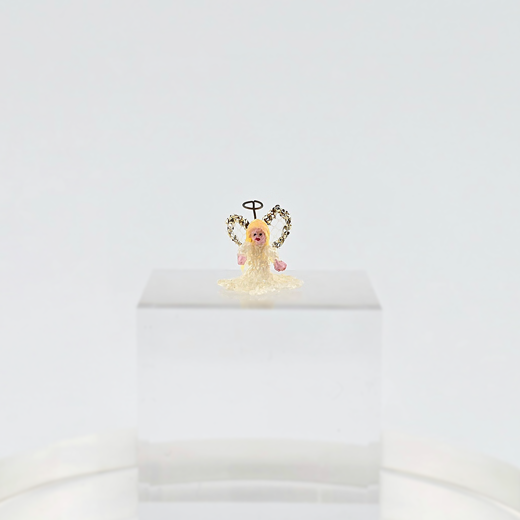 tiny angel tree topper for Christmas on a white background