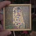 Load image into Gallery viewer, Framed miniature artwork painting of 'The Kiss' by Gustav Klimt held by a hand, by Sam Kelm
