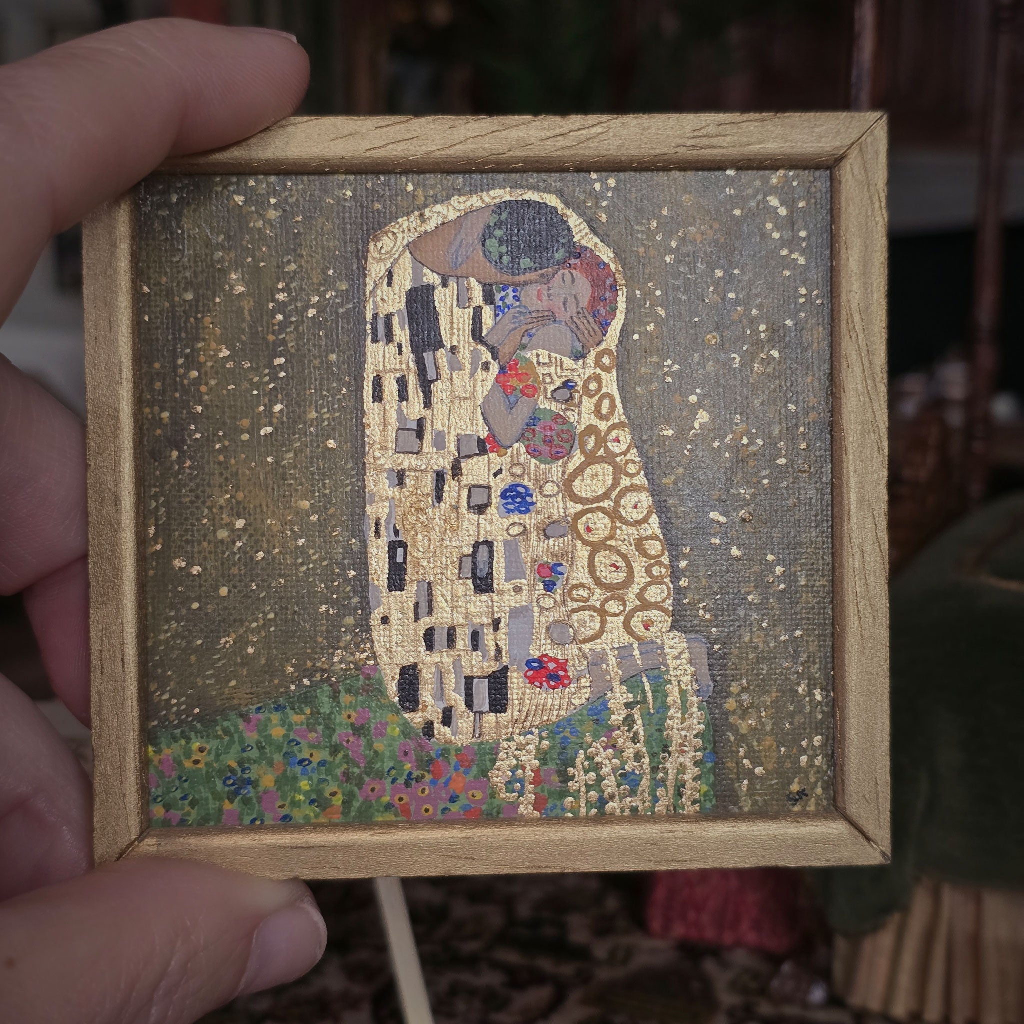Framed miniature artwork painting of 'The Kiss' by Gustav Klimt held by a hand, by Sam Kelm