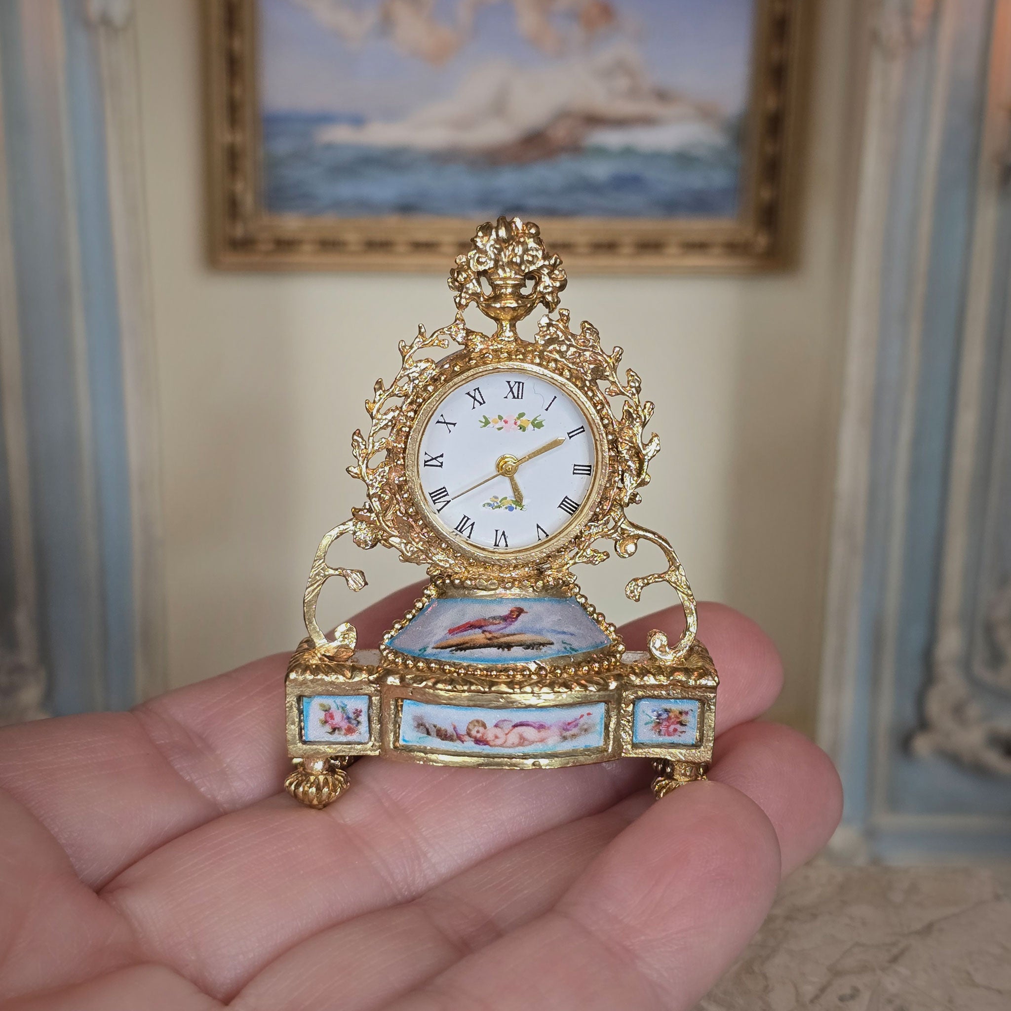 Miniature ornate clock held in a hand with a decorative background