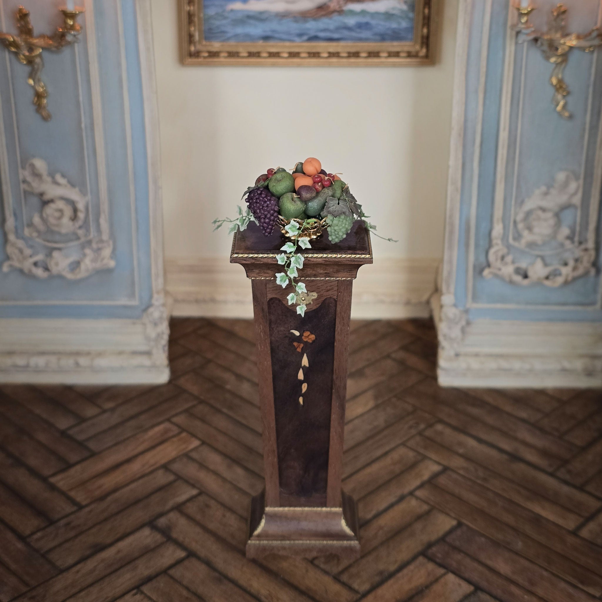 Decorative pedestal with fruits and vegetables in an ornate room.