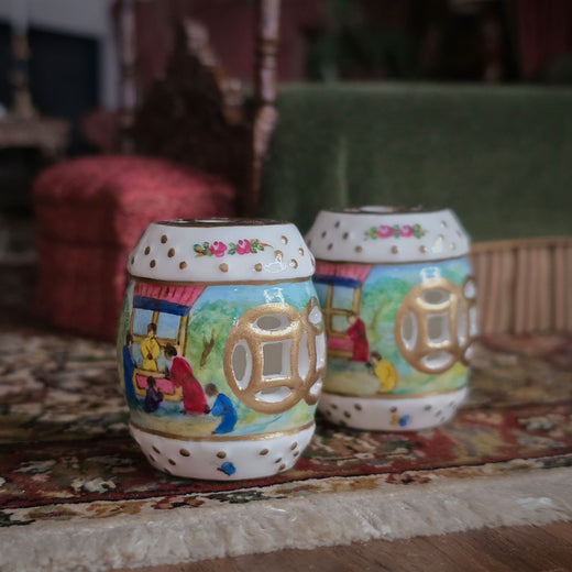 Decorative porcelain garden seats with colorful designs, shown on a patterned rug.