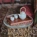 Load image into Gallery viewer, Tea set with a teapot and cups on a wooden tray on a glass table.
