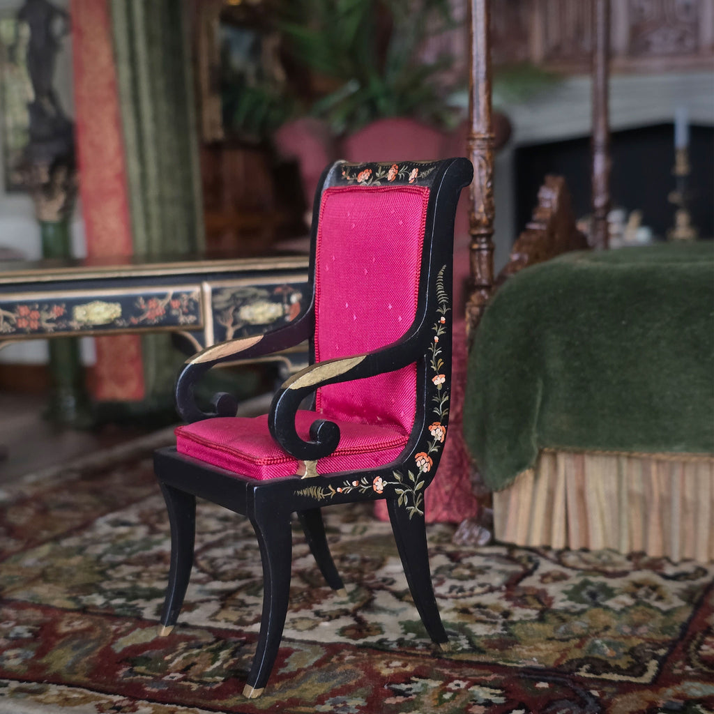 Chair with red silk upholstered cushion and hand painted Chinoiserie black frame in a vintage room setting